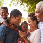 Multi generation black family look at each other in garden