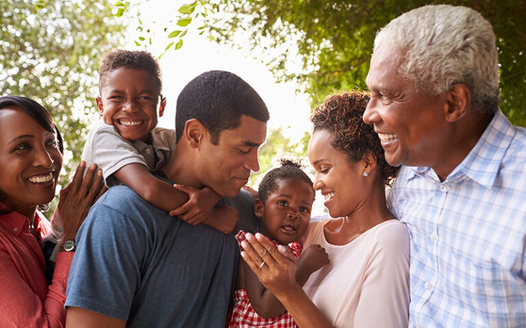 Multi generation black family look at each other in garden